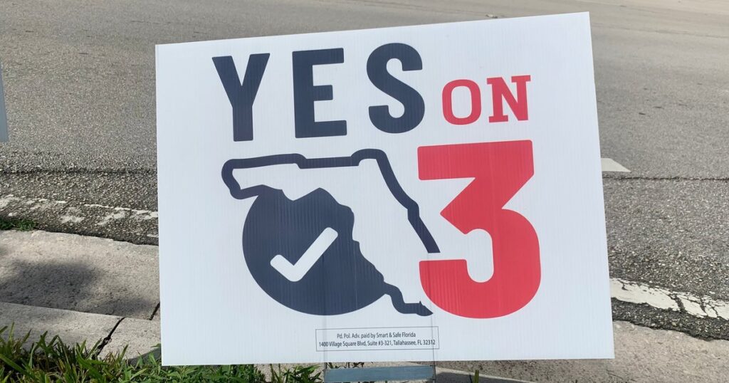 Campaign sign reading 'YES ON 3' with a Florida outline and a checkmark, placed on a sidewalk.